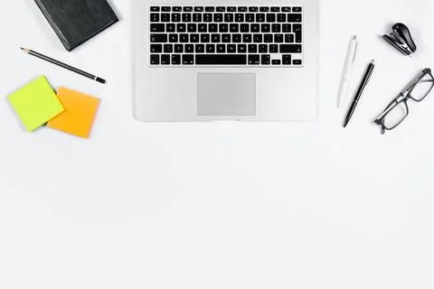 Working table top view, flat lay. Business items on a white table, laptop, cl Stock Photos