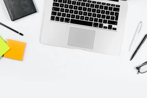Working table top view, flat lay. Business items on a white table, laptop, cl Stock Photos