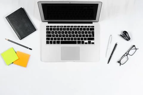Working table top view, flat lay. Business items on a white table, laptop, cl Stock Photos