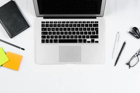 Working table top view, flat lay. Business items on a white table, laptop, cl Stock Photos