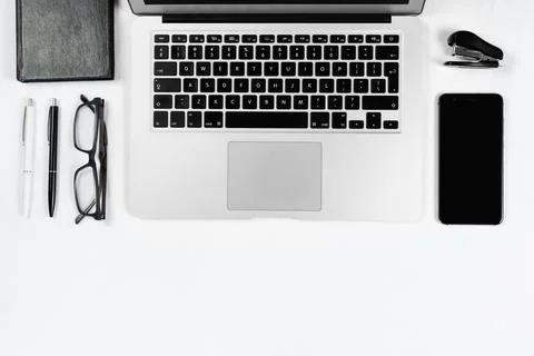 Working table top view, flat lay. Business items on a white table, laptop, cl Stock Photos