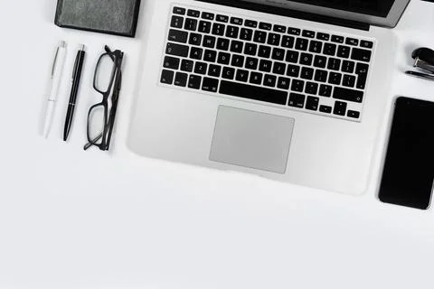 Working table top view, flat lay. Business items on a white table, laptop, cl Stock Photos
