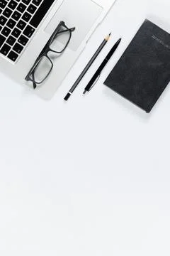 Working table top view, flat lay. Business items on a white table, laptop, ph Stock Photos