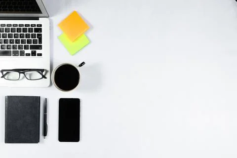 Working table top view, flat lay. Business items on a white table, laptop, ph Stock Photos