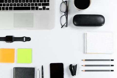 Working table top view, flat lay. Business items on a white table, laptop, cl Stock Photos