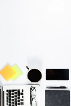 Working table top view, flat lay. Business items on a white table, laptop, ph Stock Photos