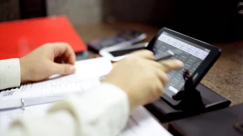 Working on tablet with paperwork Stock Footage 76787170