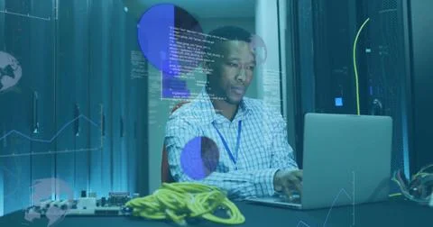 Working tech typing laptop in server room aisle, wearing checked shirt, blue Stock Photos