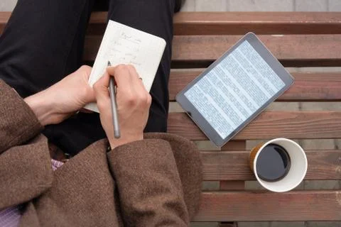 Working with text outside in town with note pad and tablet computer, top view Stock Photos