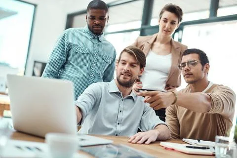 Working on their group task. a group of businesspeople working together on a Stock Photos