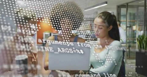 Working three-person team leaning over laptop at office, with glass showing Stock Photos
