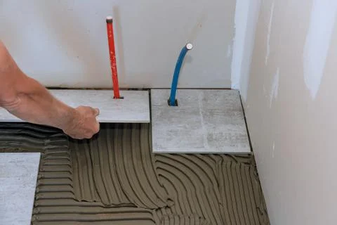 Working tiles lay a tile on the floor Stock Photos
