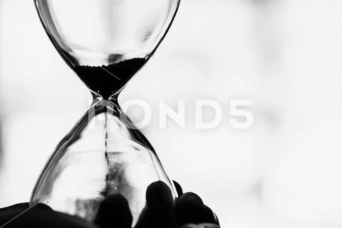 Working times countdown concept. Closeup Hourglass black and white vintage to Stock Photos