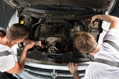 Working together on a car engine Stock Photos
