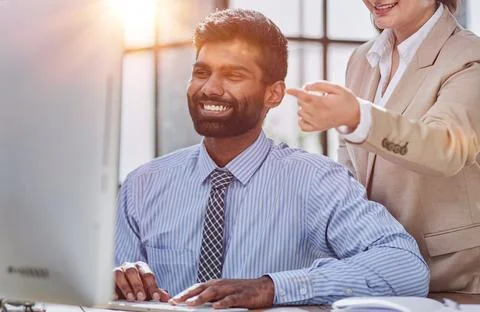 Working together on project. Two young business colleagues working on computer Stock Photos
