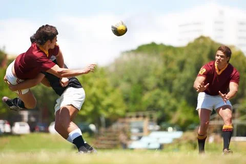Working together for stronger unity. Shot of a young rugby player executing a Stock Photos