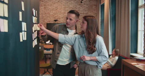 WORKING TOGETHER Young 20-25 European business people, man and woman use Video stock 185747775
