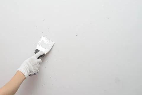 Working tool, spatula in hand against the background of a white wall, work pl Stock Photos