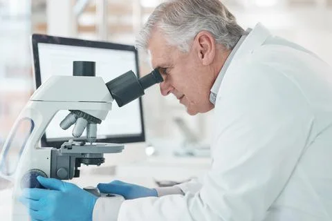 Working towards the precise cure. a mature scientist using a microscope in a lab Stock Photos