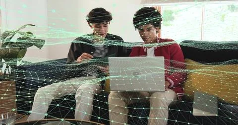 Working two men in red jacket, striped top using laptop and tablet, living room, Stock Photos
