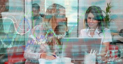 Working two women wearing patterned top white top reviewing laptop at office, Stock Photos