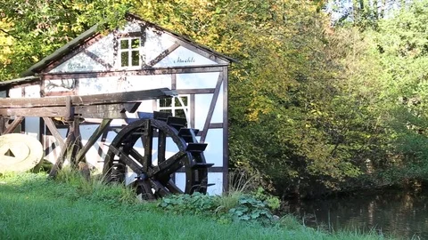 Working water mill wheel turning by the power of water at small lake Stock Footage 81319759