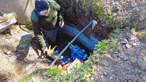 Working on a water pump installation in a rural area during the afternoon Stockbeeldmateriaal 337125306