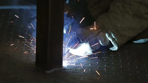 The working welder processes the metal, prepares the base. A man in a protective Video stock 87952461