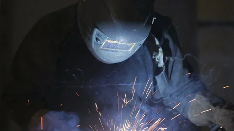 The working welder processes the metal, prepares the base. A man in a protective Stock Footage 87952501
