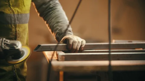 Working in the welding workshop - grinding the cut of the metal beam Stock Footage 128261120