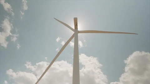 A working wind turbine against a backdrop of blue sky and white clouds Stock Footage 313465491