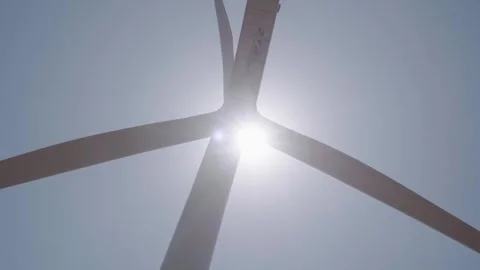 A working wind turbine against a backdrop of blue sky Stock Footage 313465493