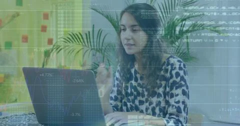 Working woman in patterned blouse typing on laptop at bright workspace with Stock Photos