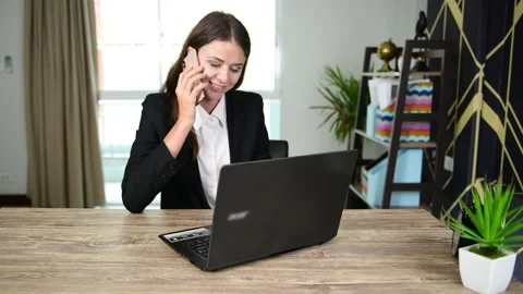 Working women are using computers and the phone to talk about work in office. Stock Footage 139157873