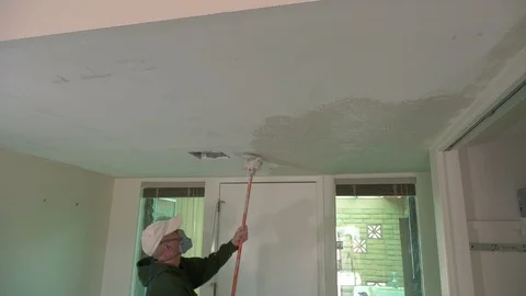 A workman applying stucco texture to a ceiling Stock Footage 104636662