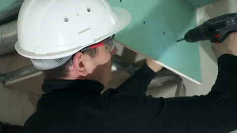 Workman in Builder Helmet Contractor Tighten Screws Electric Screwdriver Drill Vídeos de archivo 156575584