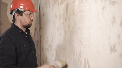 Workman is covering wall in living flat by building mortar, using brush Stock Footage 86733145