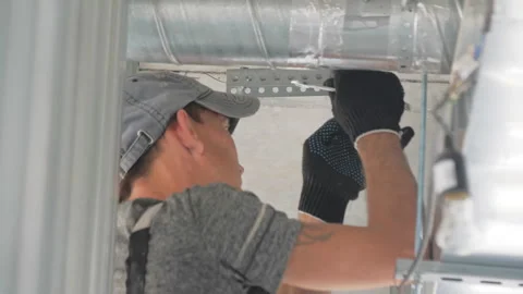 Workman fastens perforated details of pipe with nuts in hall Video stock 243999459