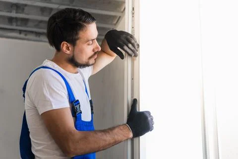 The workman installs a window frame in the room Stock Photos