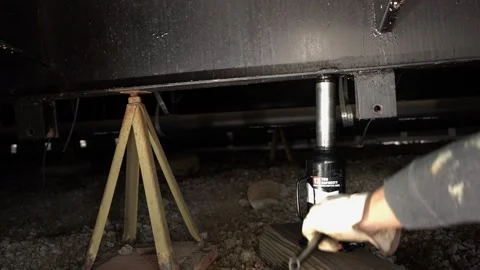 A workman jacking up a manufactured home to level it Stock Footage 205528821