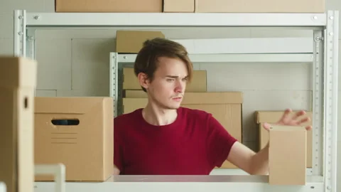 Workman looking for parcel and taking it, employee of warehouse takes delivery Stock Footage 157505834