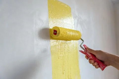 Workman painting the wall in yellow. Stock Photos
