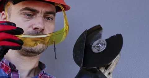 Workman with part of broken saw in protective glasses. Stock Footage 258071248
