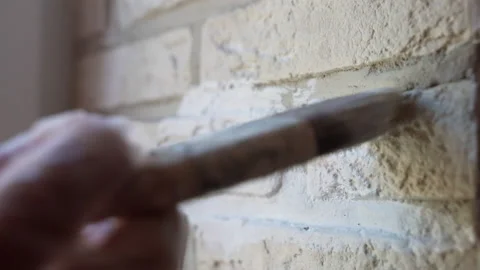 Workman in protective gloves applying white colour with paintbrush on renovated Stock-Footage 208422320