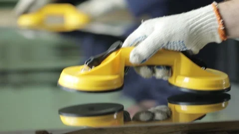Workman puts yellow handle with suctions on aluminium sheet Stock Footage 138941482
