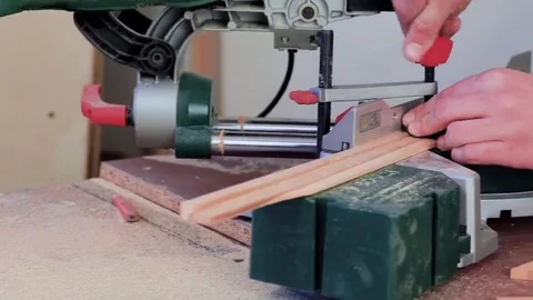 Workman sawing wood using a miter saw Stock Footage 69205304