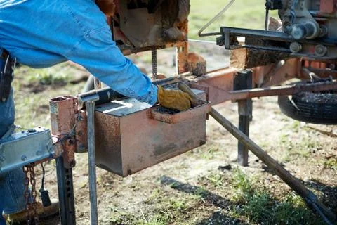 Workman at a sawmill adjusting a milling machine Foto stock