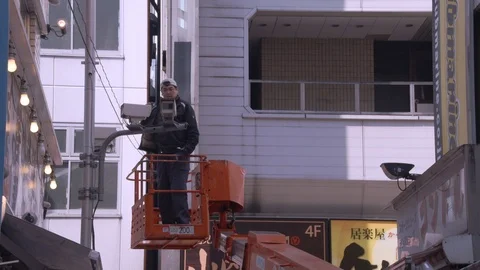 Workman services CCTV surveillance camera from crane Stockbeeldmateriaal 100100293