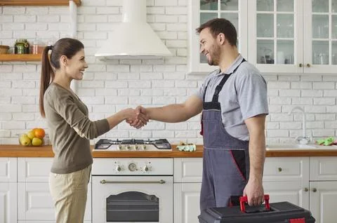 Workman Shaking Hands With Client In Kitchen Stock Photos