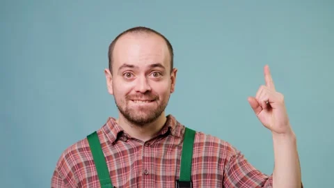 A workman, in a studio shot, with a blue background, looking at camera ecstatic Stock Footage 304809425